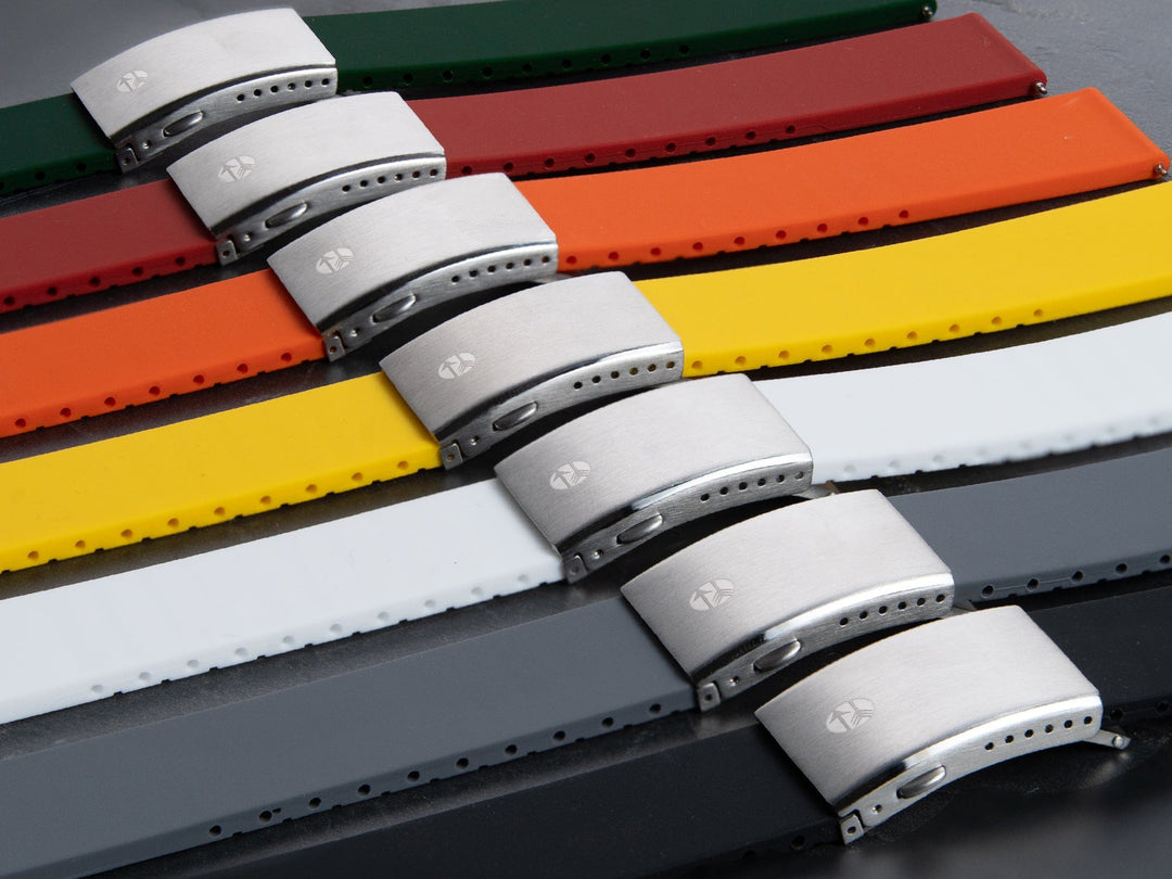 Multiple silicone watch straps with sport clasp buckles in green, orange, yellow, white, and gray